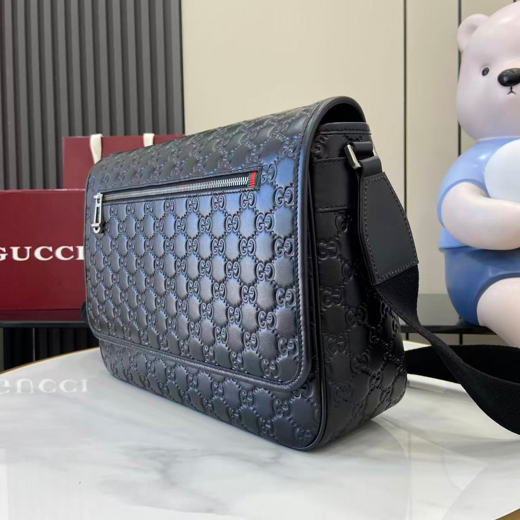Blue embossed GG flap crossbody bag with black strap and gold-tone hardware