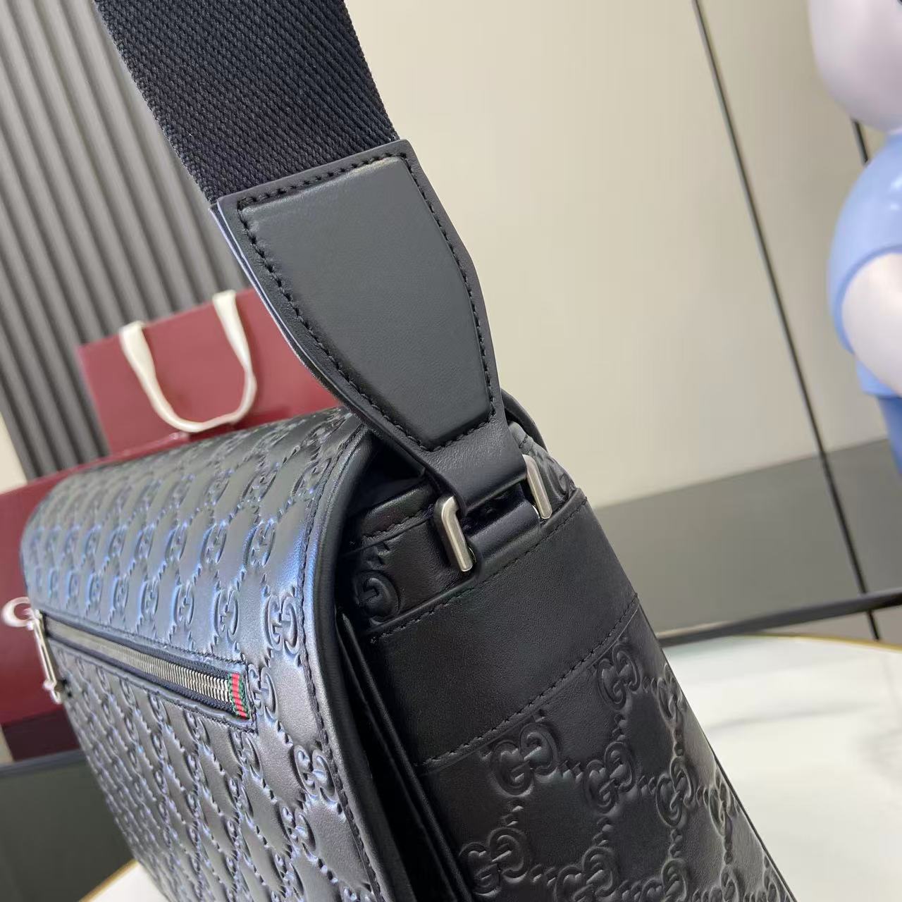 Gucci bag with embossed dark leather, adjustable strap and top handle