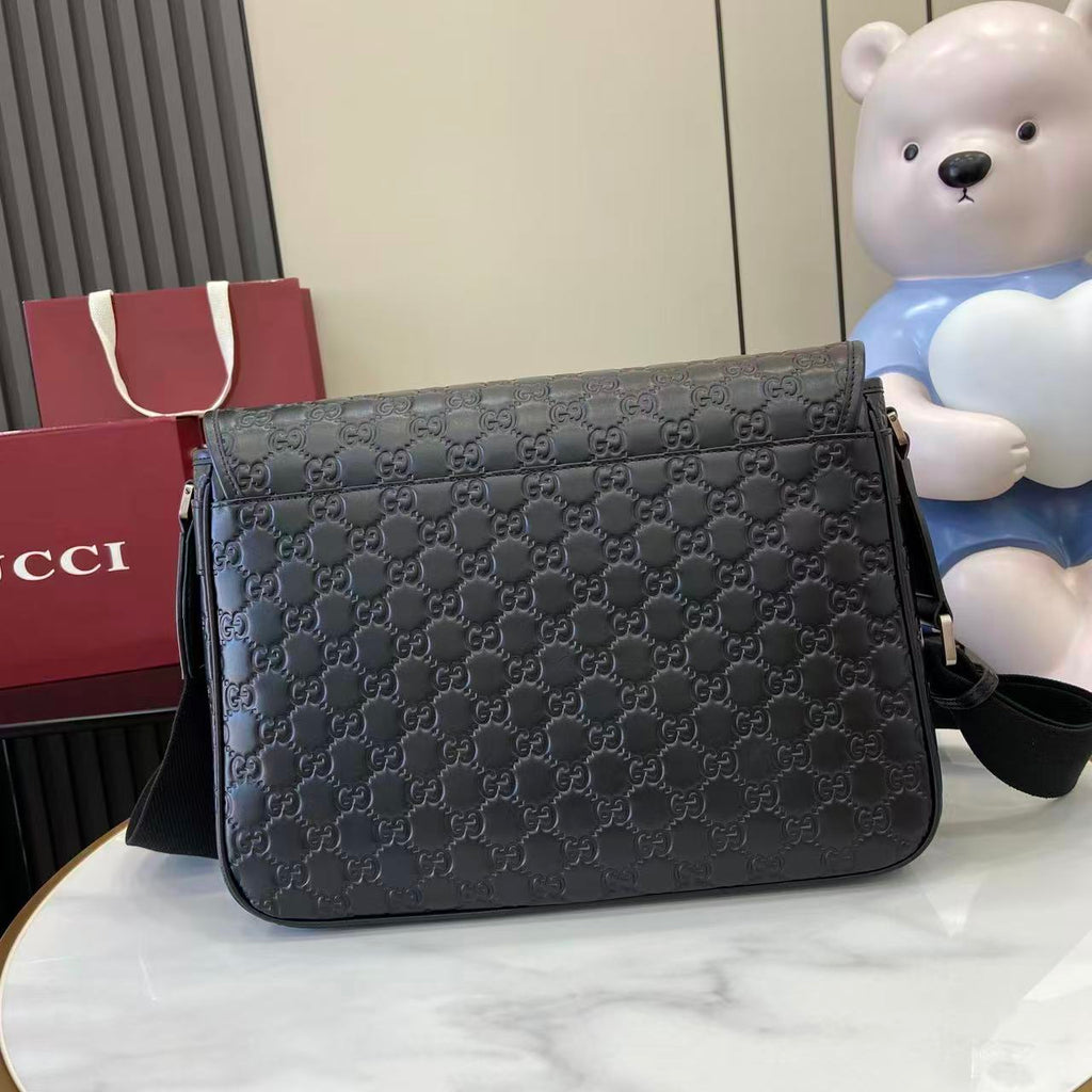 Blue embossed GG crossbody bag with curved flap and front zip closure