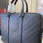 Gucci handbag close-up: navy GG monogram with front strap and top handles