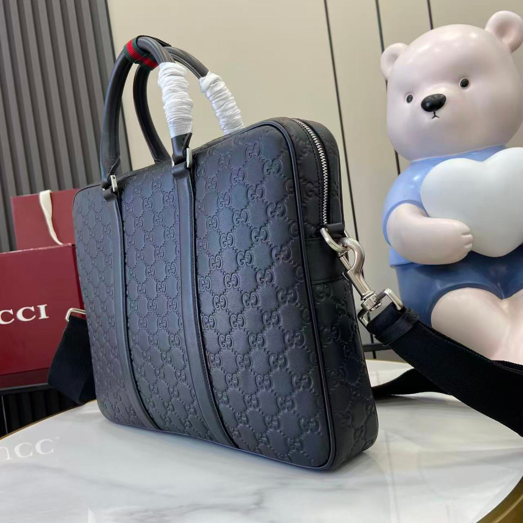 Gucci handbag side view in navy with zipper trim and GG monogram pattern