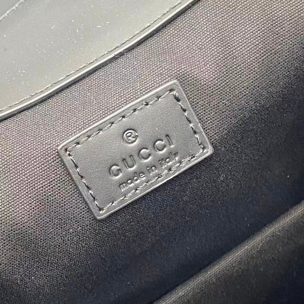 Gucci logo leather patch on inner lining of bag, rectangular with stitched border
