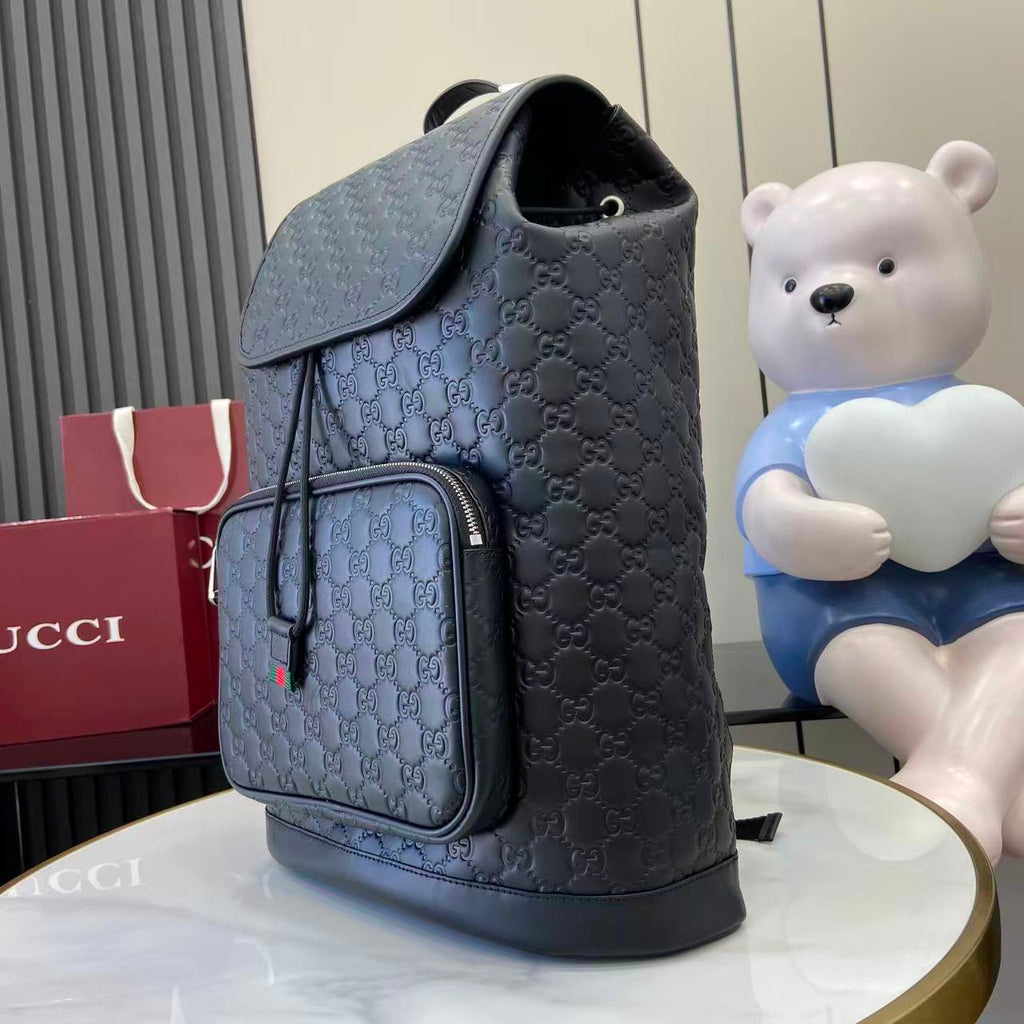 Gucci bag backpack side view with front zip pocket and embossed GG pattern, light blue-gray