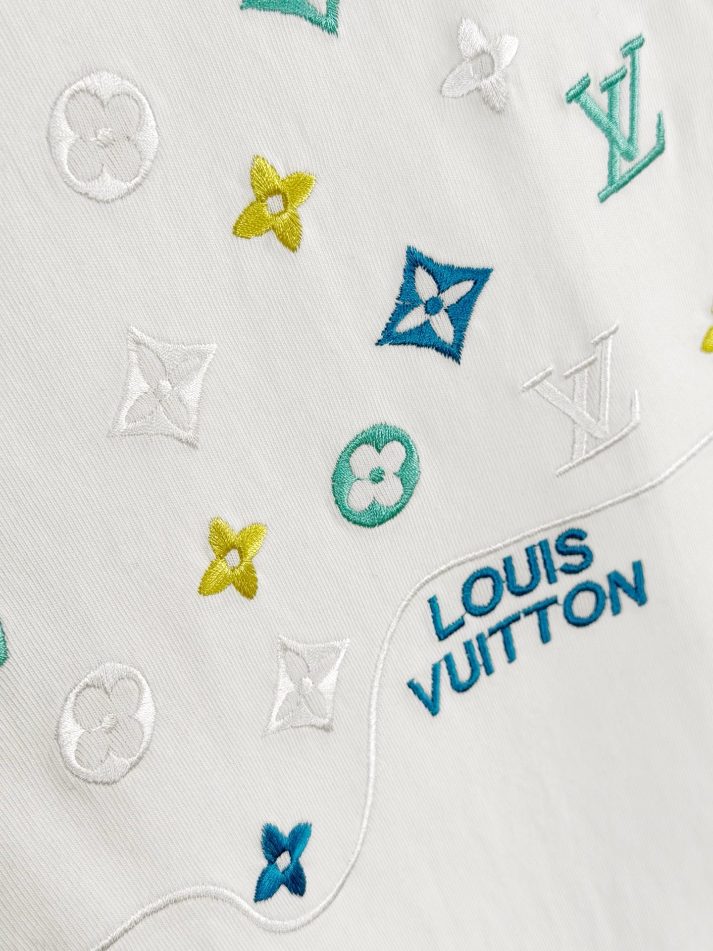 Louis Vuitton white T-shirt closeup with Louis Vuitton logo badge