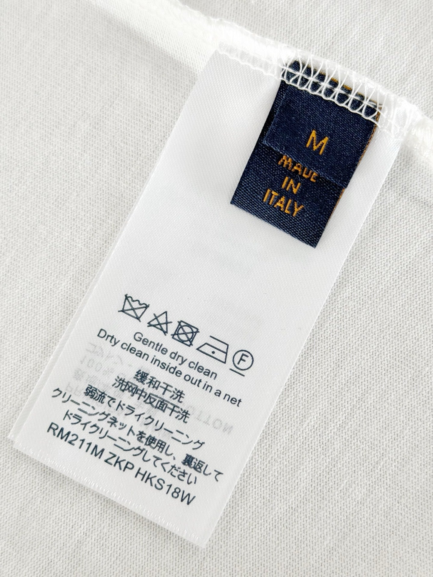Louis Vuitton T-shirt size and care label, navy tag on white fabric