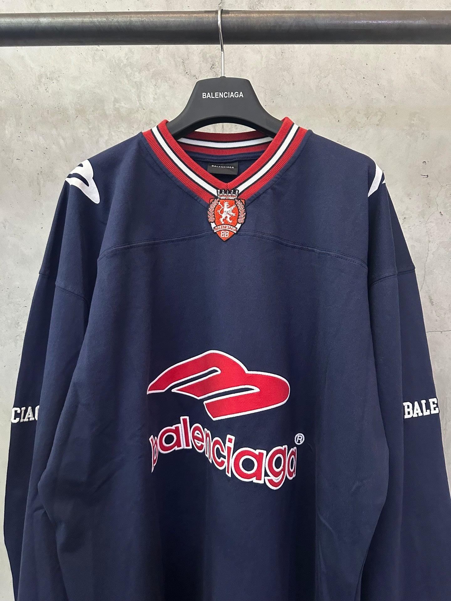 Balenciaga navy sweatshirt with red logo on chest and striped V-neck collar