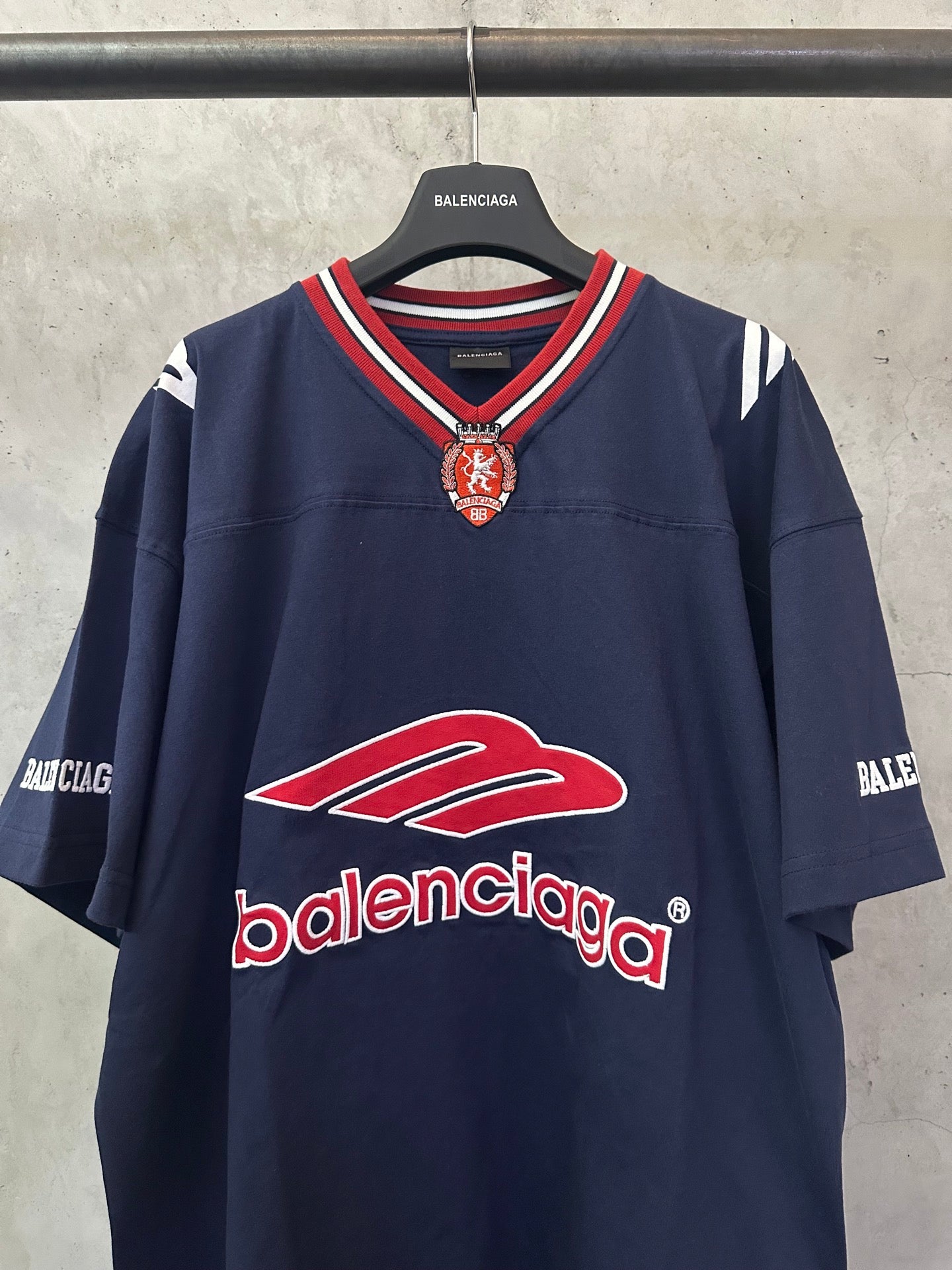 Navy short-sleeve polo shirt with red Balenciaga logo at chest and V-neck trim