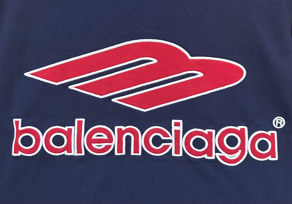 Close-up of navy short-sleeve polo shirt with red Balenciaga logo