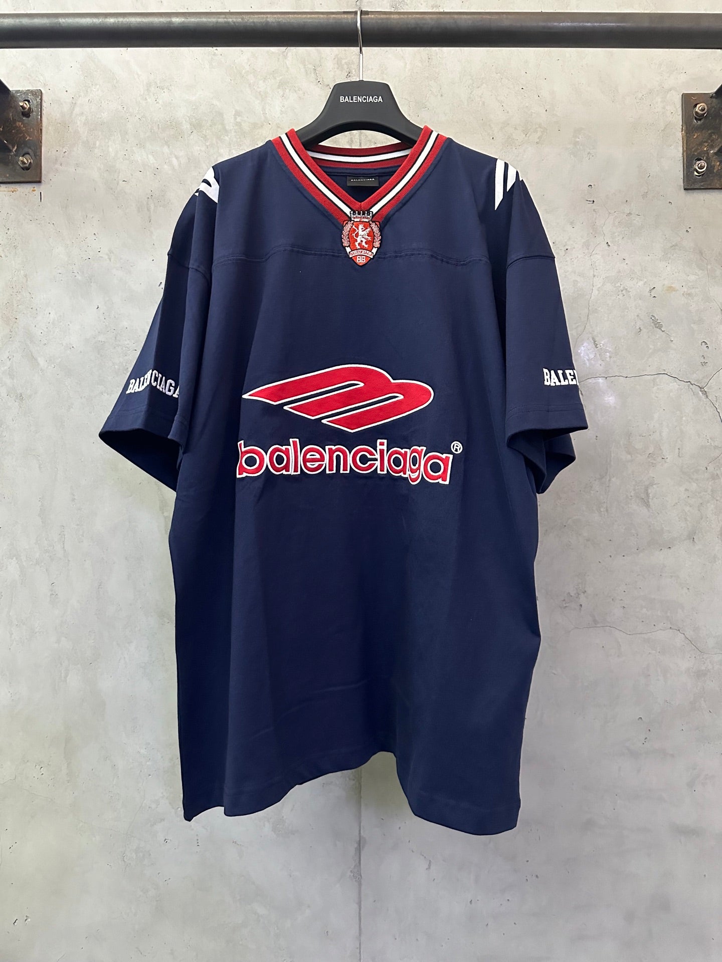 Navy short-sleeve polo shirt with red Balenciaga logo and striped V-neck trim