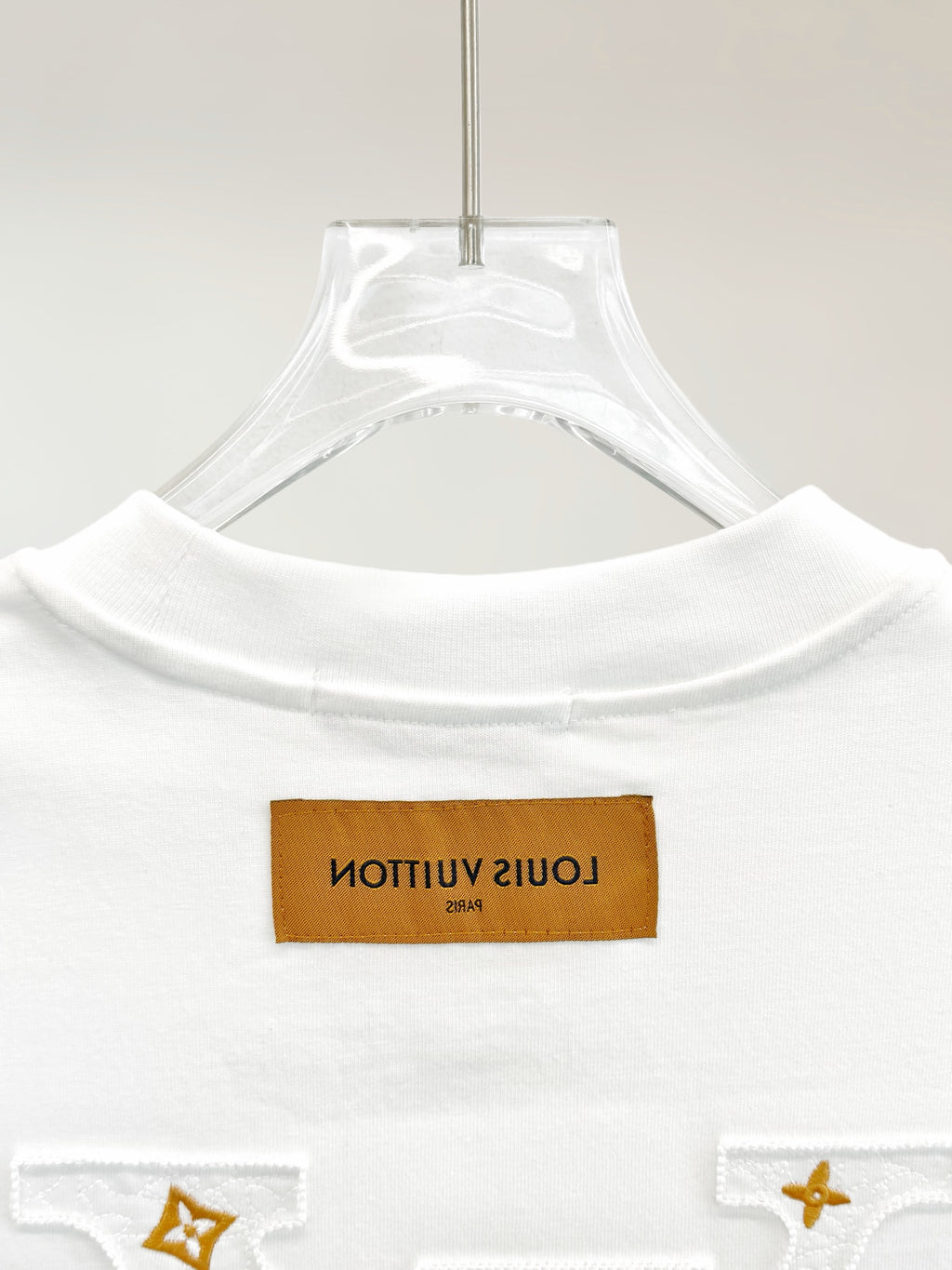 White T-shirt with ribbed crew neck and rectangular logo patch at chest