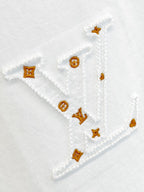 White T-shirt embroidery with gold and orange motifs stitched on the fabric