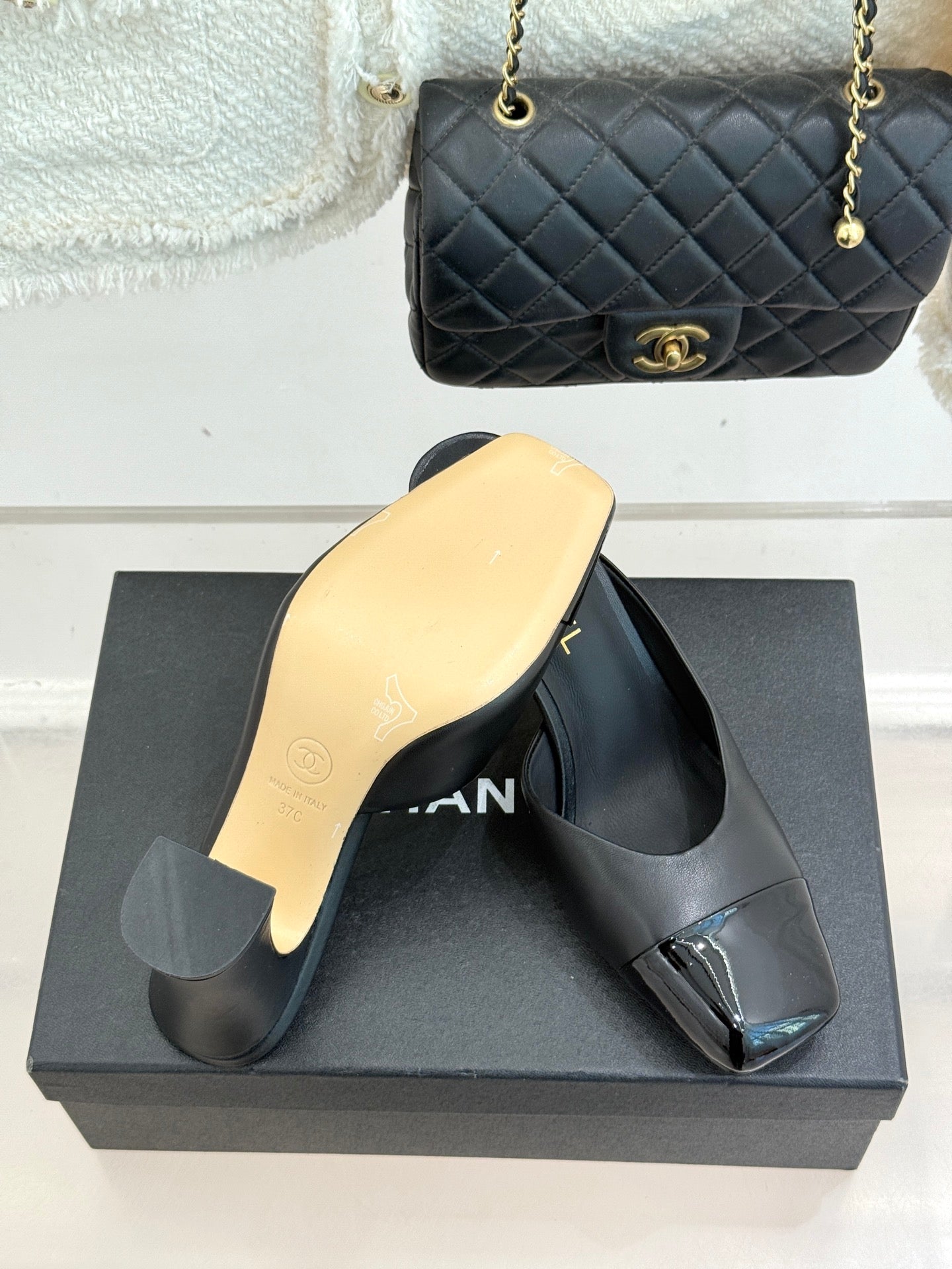 Black Chanel heeled mules with gold logo strap and smooth leather finish