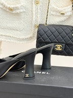 Black Chanel heeled mules showing heel detail with gold logo