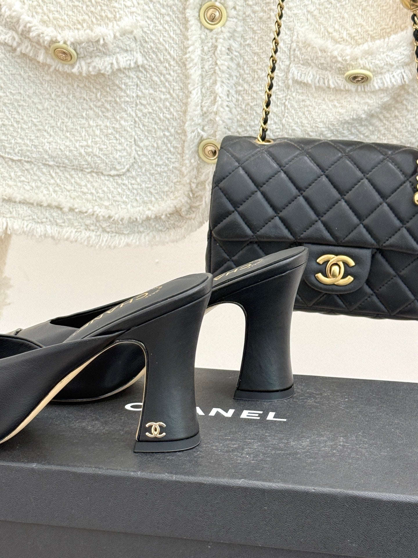Black Chanel heeled mules showing heel detail with gold logo
