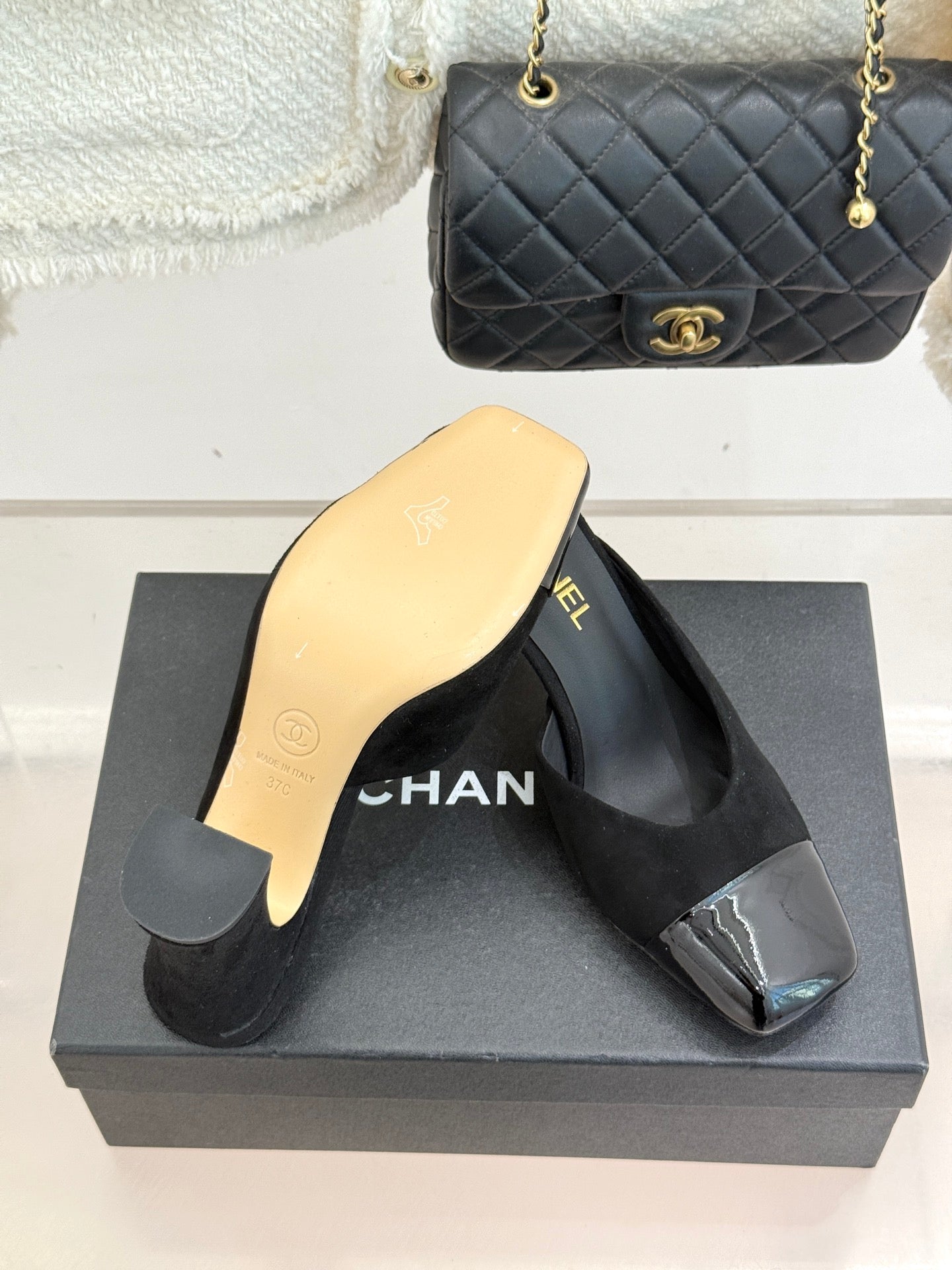 Black heeled slide sandals with gold Chanel branding and glossy toe panel accents