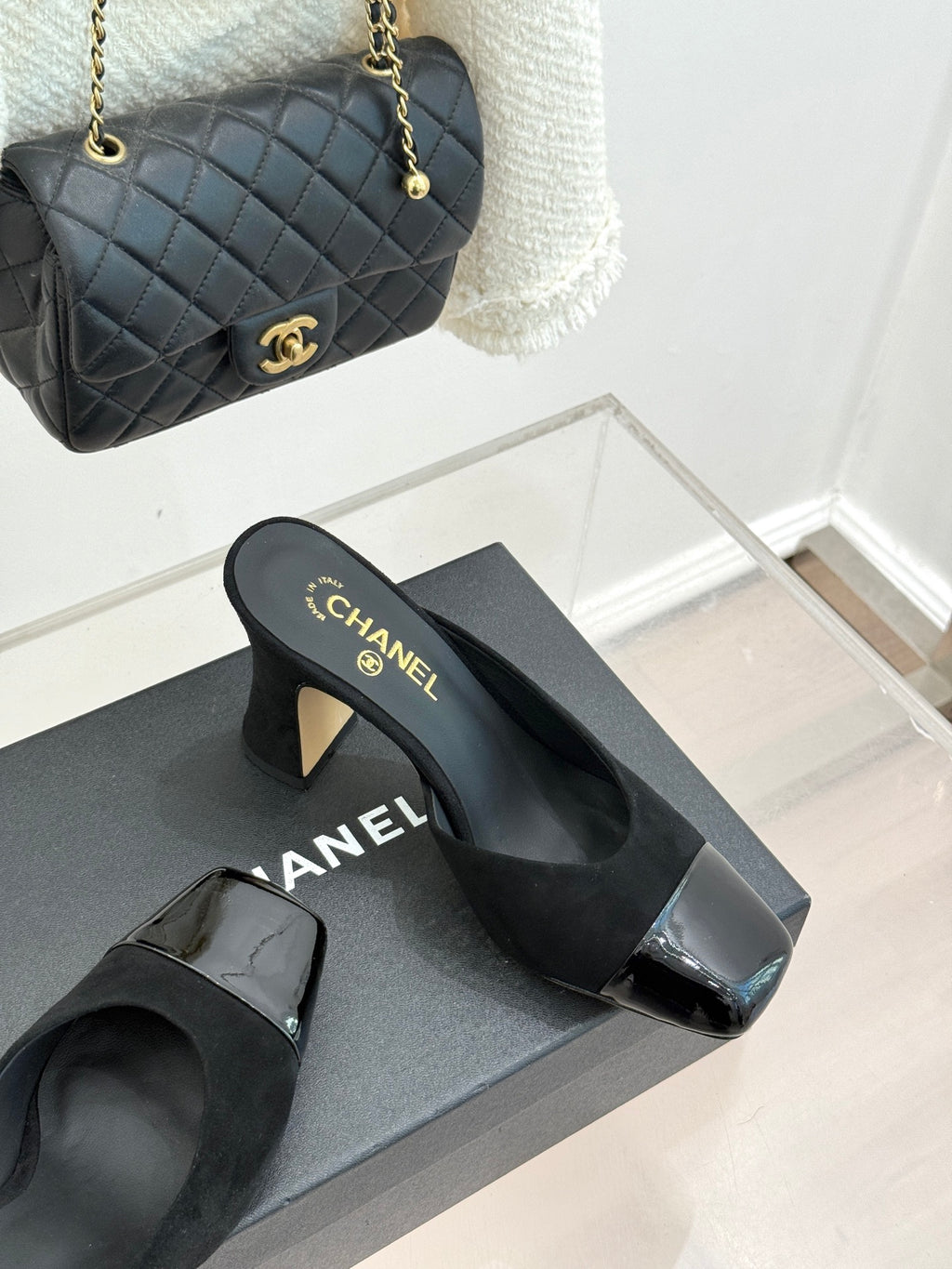Black heeled slide sandals with gold heel detail and glossy square toe caps