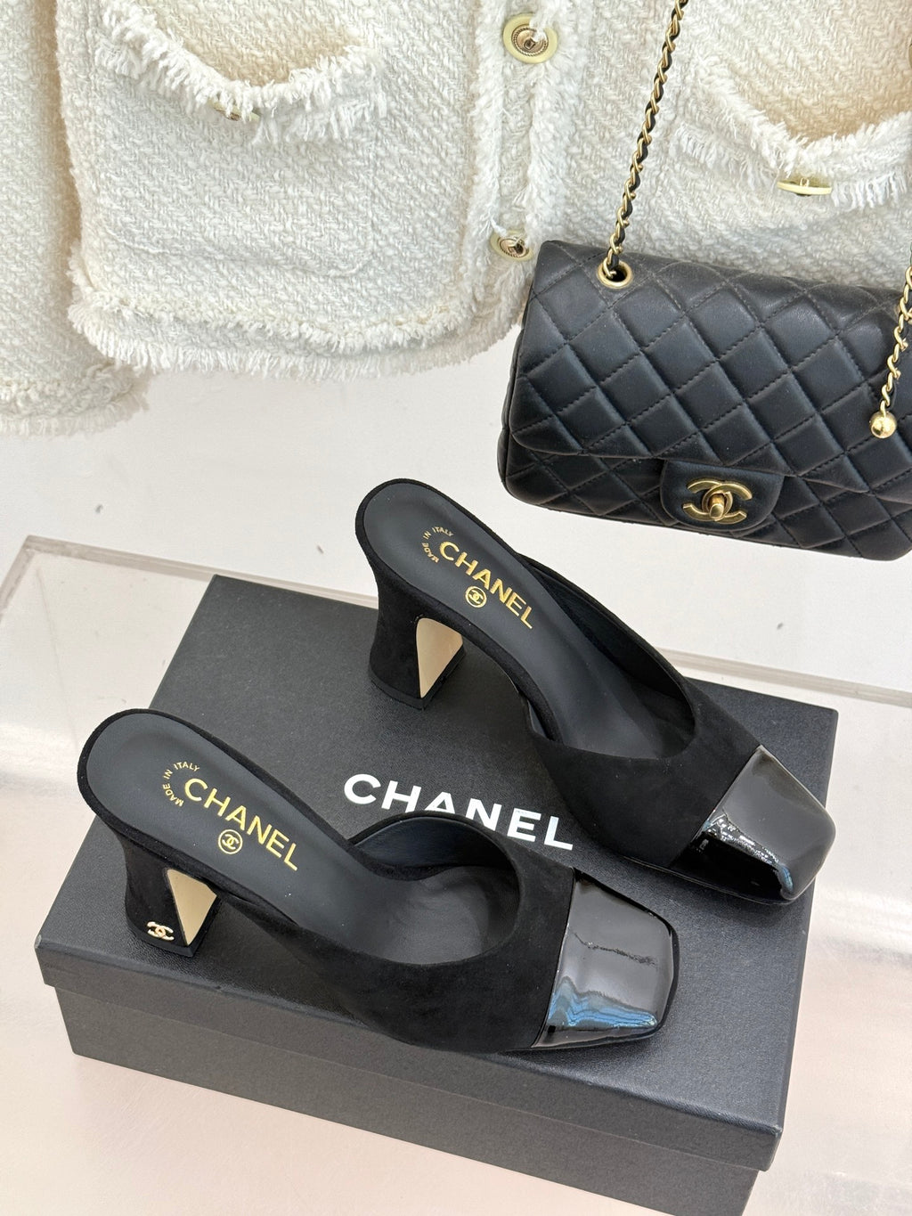 Black heeled slide mules with gold Chanel logo on footbed and glossy toe inserts