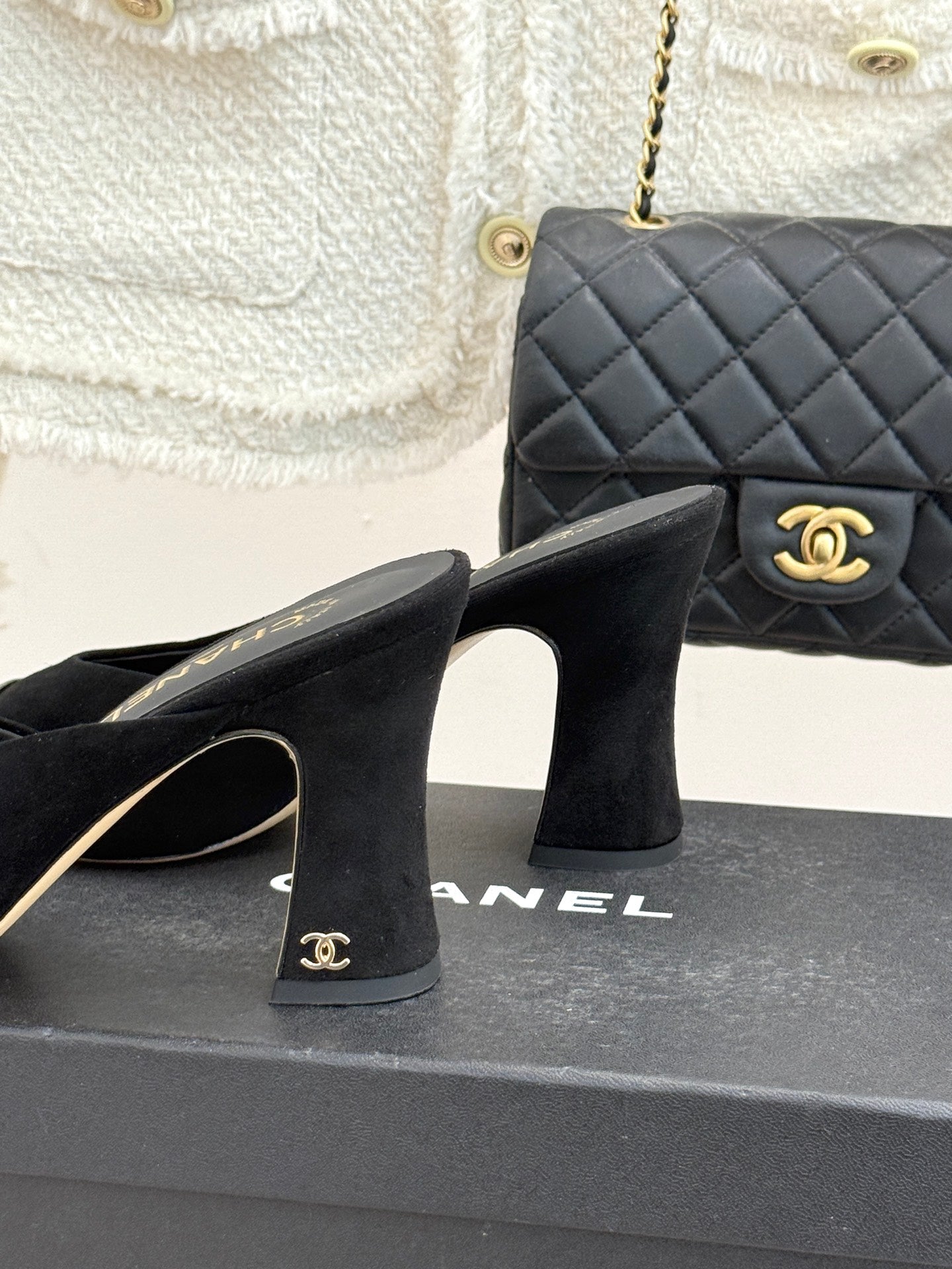 Black heeled mules with gold Chanel heel mark and glossy silver toe panels