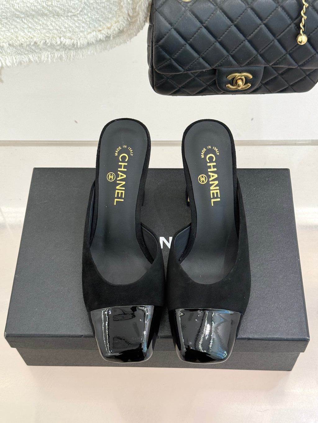 Black heeled mule sandals with square-toe design and silver patent-style toe panels