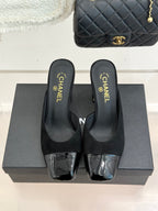 Black heeled mule sandals with square-toe design and silver patent-style toe panels