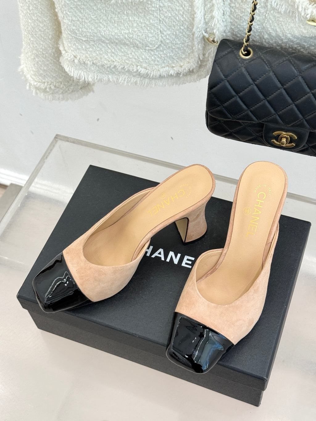 Beige suede mules with black patent toe strap and block heel, open side profile