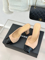 Beige suede mules with black patent toe strap and block heel, open side profile