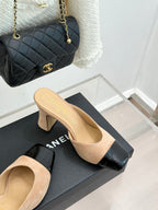Beige suede mules with black patent toe trim and block heels, side opening
