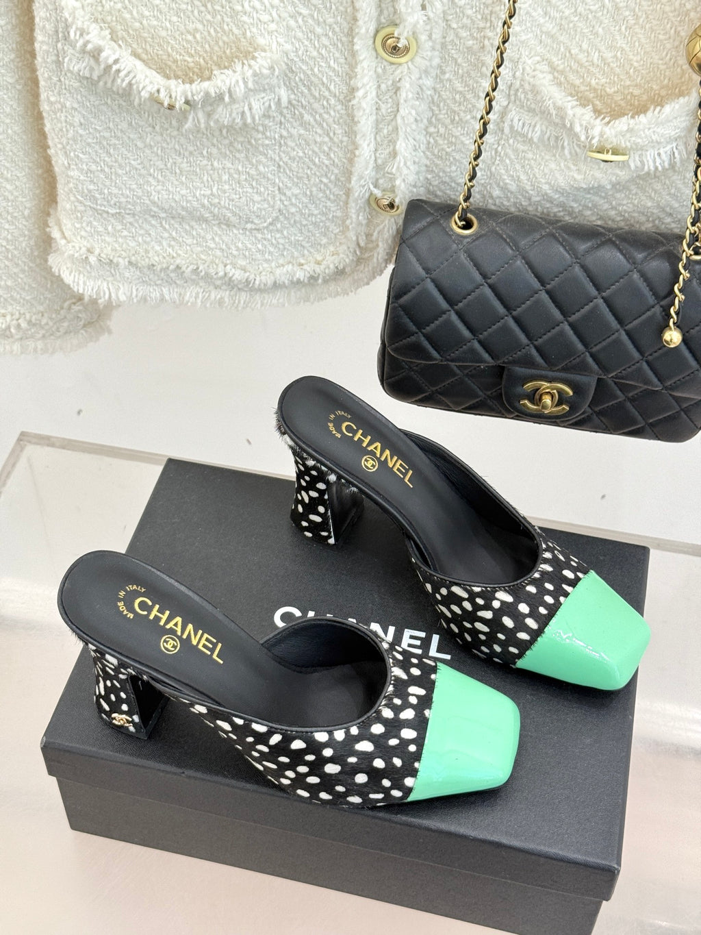 Pair of mule heels on box, black with white spots and mint green patent toe