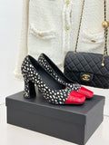 Black and white polka-dot high heels with red glossy toe cap, black heel.