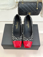 Polka-dot black pumps with red glossy toe cap and CHANEL logo on lining.