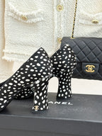 Polka-dot black high heels with red glossy toe cap, heel and toe close-up.