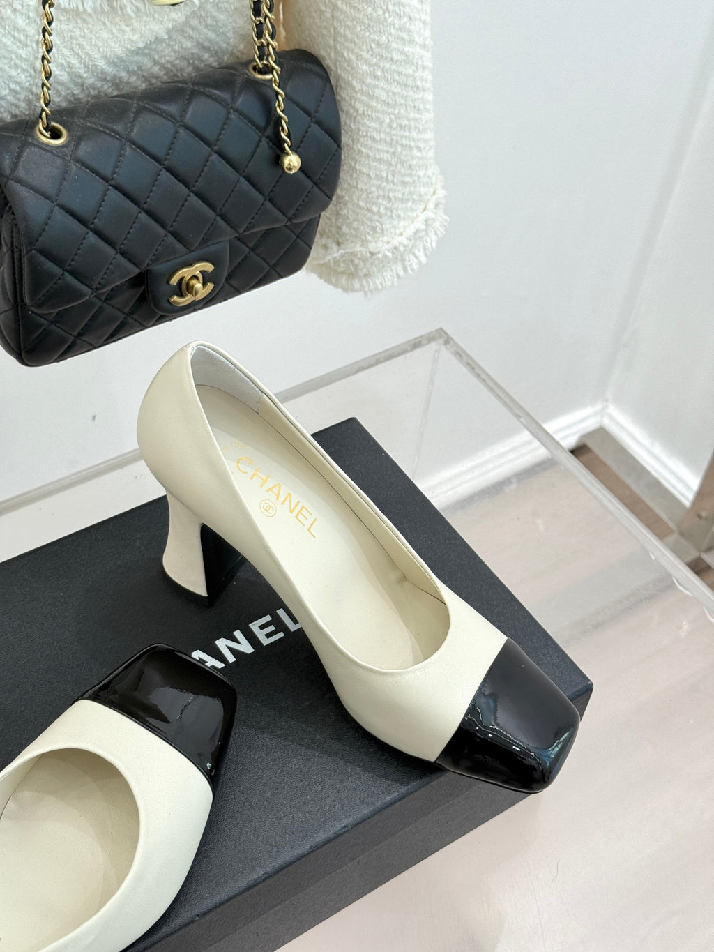 White heeled shoes with glossy black toe cap and side strap detail
