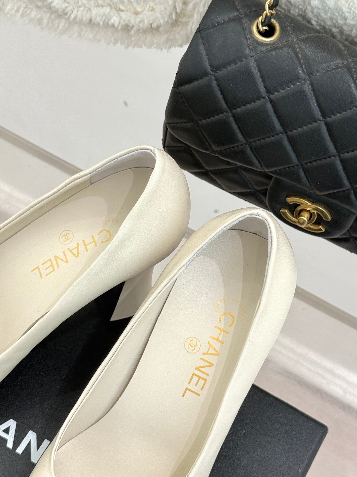 Close-up of white heeled shoe interior and gold lettering on insole