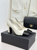 White two-tone heeled shoes with glossy black toe and ankle strap