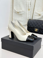 White two-tone heeled shoes with glossy black toe and ankle strap