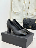 Black patent-toe heeled pumps with Chanel logo on the heel