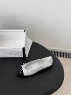 Two-tone leather ballet flat with lace-up bow at the toe, side view