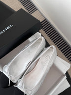 Two-tone leather ballet flats with lace-up bows, close-up on uppers