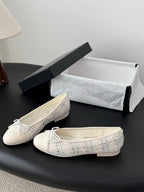 Pair of cream tweed ballet flats with bow ties, presented with shoe box