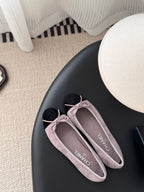 Chanel ballet flats with mauve suede uppers and black toe caps, tied pink bows