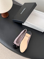Chanel mauve suede ballet flats with black toe cap, bow tie, and smooth insole