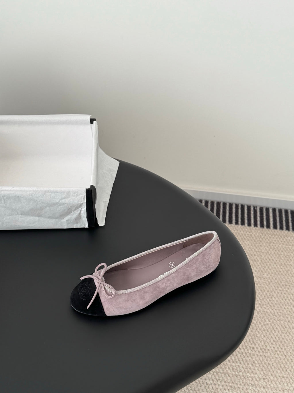Chanel suede ballet flat with mauve upper, black toe cap, and pink bow lace