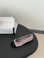 Chanel suede ballet flat with mauve upper, black toe cap, and pink bow lace