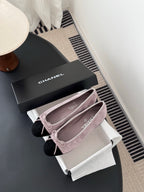 Chanel two-tone suede ballet flats with black toe caps and pink bow ties on shoes