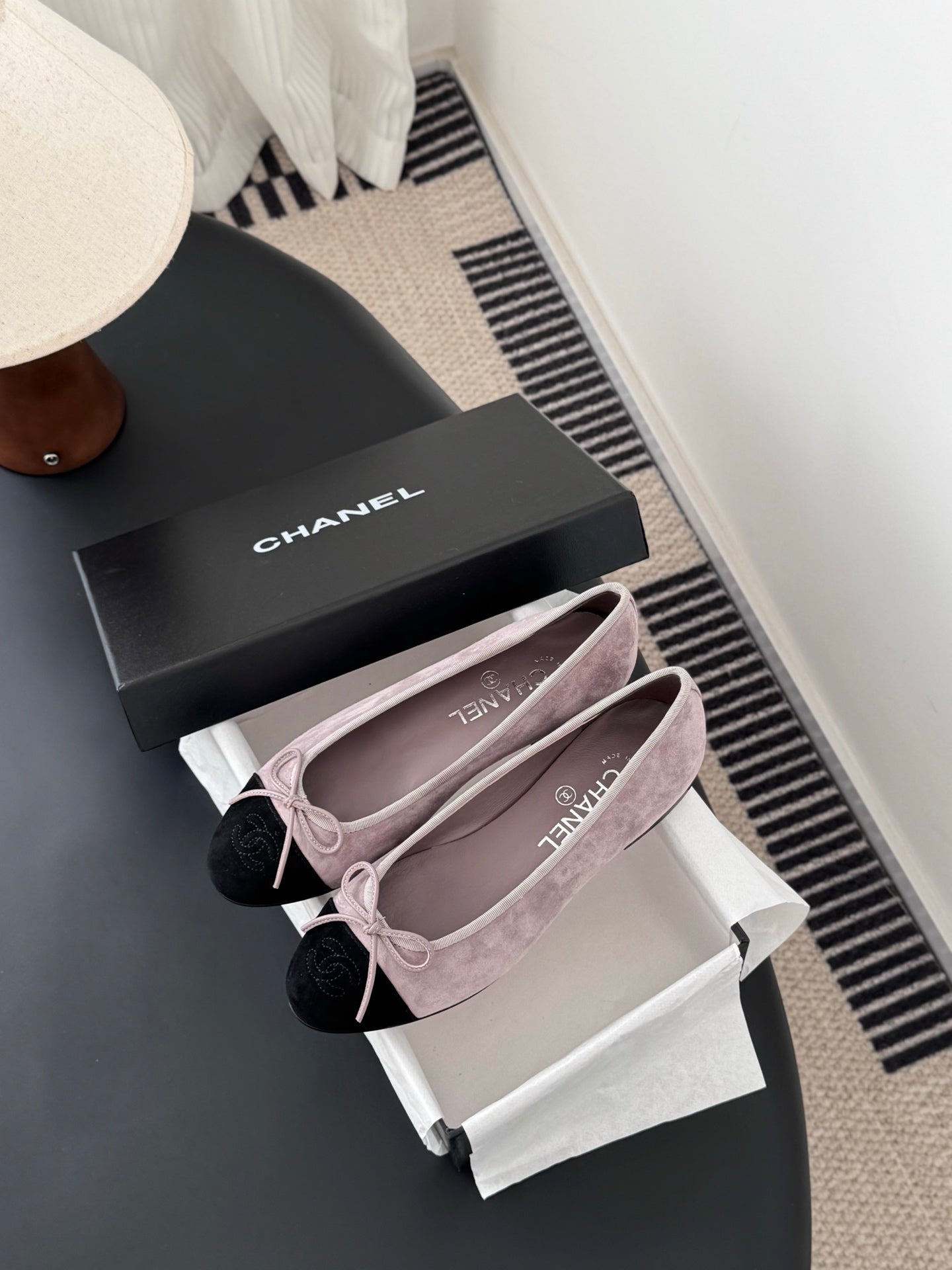 Chanel two-tone suede ballet flats with black toe caps and pink bow ties on shoes
