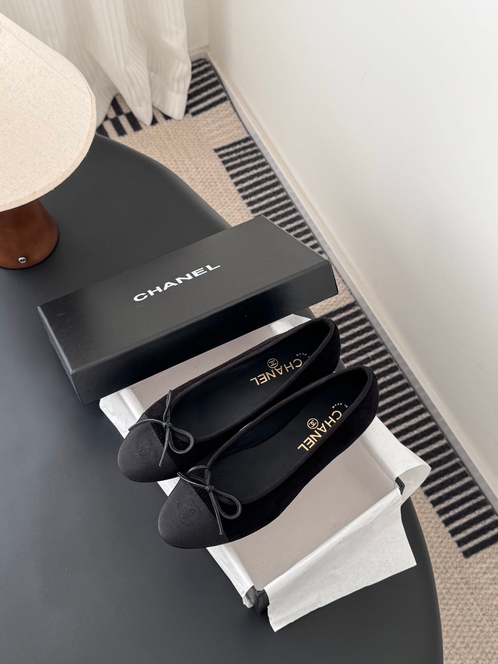 Pair of dark lace-up ballet flats with bow ties and logo insoles