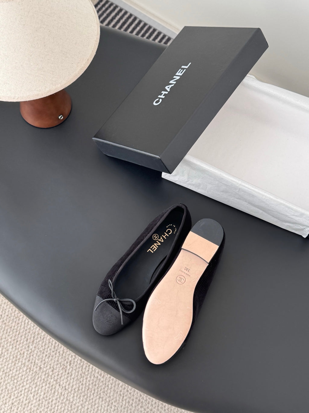 Dark lace-up ballet flats with bow ties, showing light sole underside