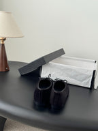 Pair of dark fabric lace-up ballet flats with bow ties, back view