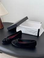 Chanel womens ballet flats, dark fabric, lace-up ribbon bows, one pair on display
