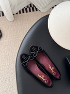 Chanel womens ballet flats, dark fabric, lace-up ribbon bows, close-up on top pair